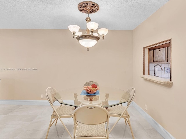 dining area with an inviting chandelier and a textured ceiling