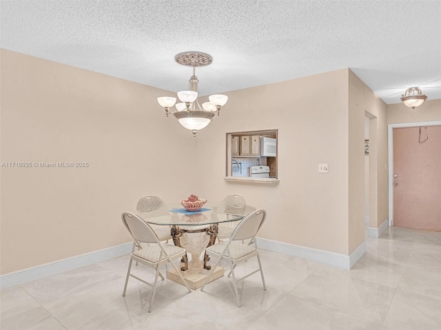 dining area featuring a textured ceiling and a chandelier