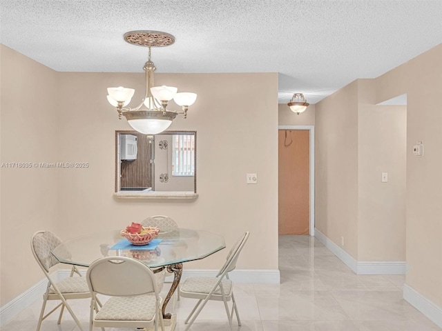 dining space featuring a textured ceiling and an inviting chandelier