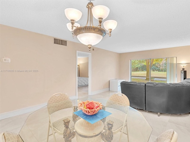 dining space featuring a textured ceiling, light tile patterned floors, and a chandelier