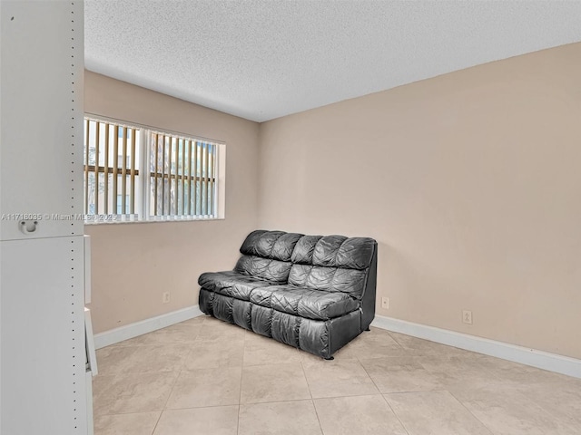 living area with a textured ceiling and light tile patterned floors