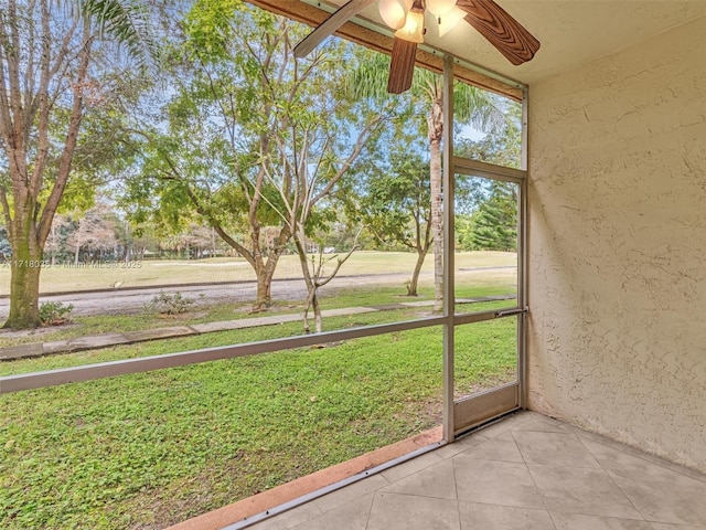 unfurnished sunroom featuring ceiling fan