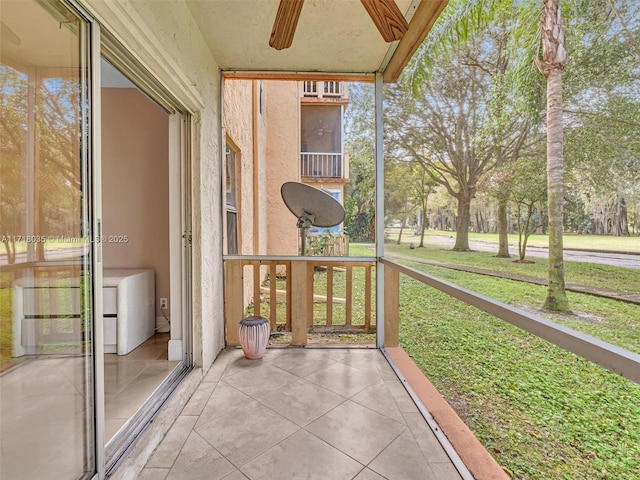 unfurnished sunroom featuring ceiling fan and plenty of natural light