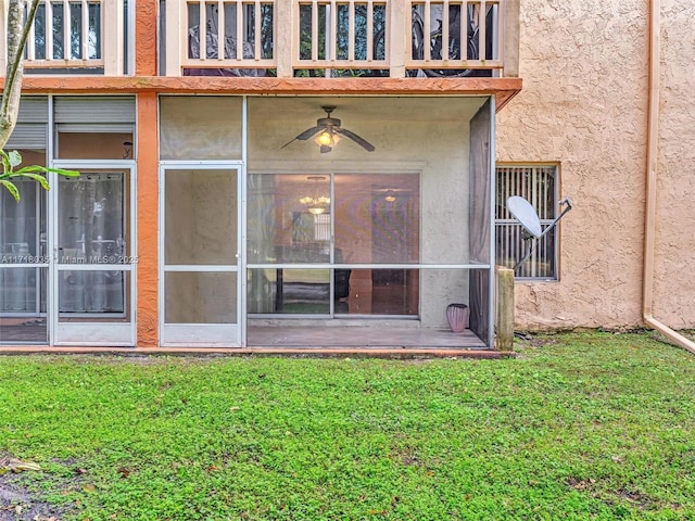 exterior space with ceiling fan and a yard