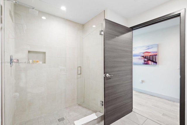 bathroom with tile patterned flooring and a shower with door