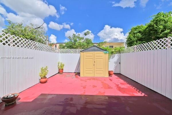 view of patio featuring a storage unit