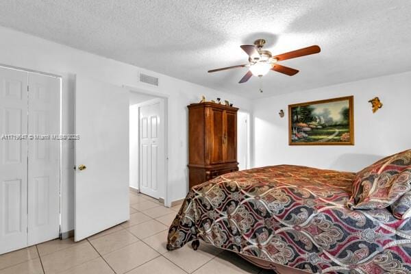 tiled bedroom featuring ceiling fan and a textured ceiling