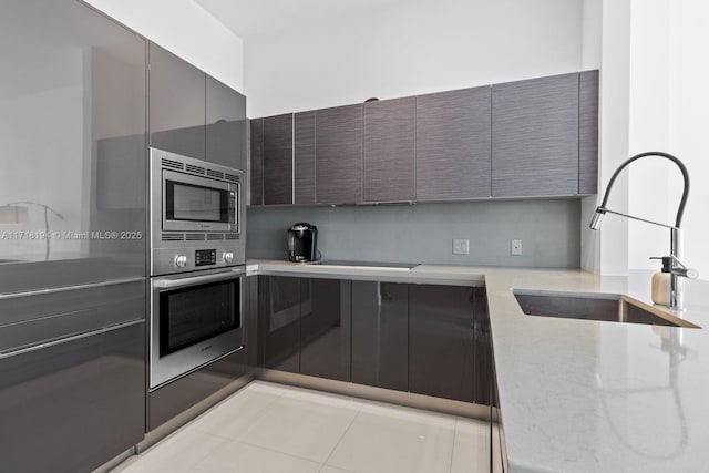 kitchen with appliances with stainless steel finishes, light tile patterned floors, and sink