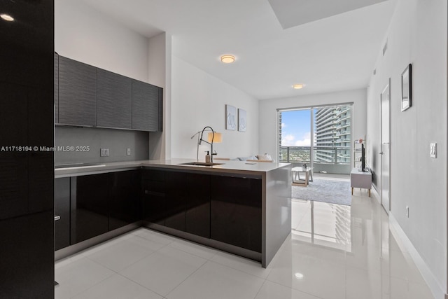 kitchen with kitchen peninsula, sink, and light tile patterned floors