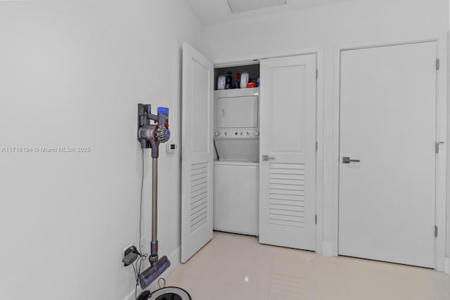 laundry area featuring stacked washer and dryer and light tile patterned flooring