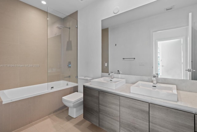 full bathroom featuring tile patterned floors, vanity, toilet, and tiled shower / bath