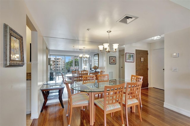 dining area with an inviting chandelier and hardwood / wood-style flooring