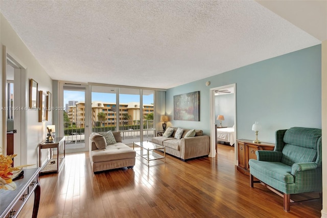 living room with expansive windows, dark hardwood / wood-style floors, and a textured ceiling