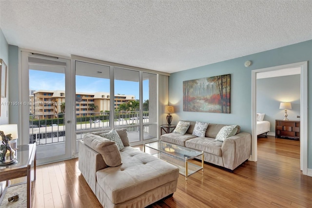 living room featuring a wall of windows, hardwood / wood-style floors, and a textured ceiling