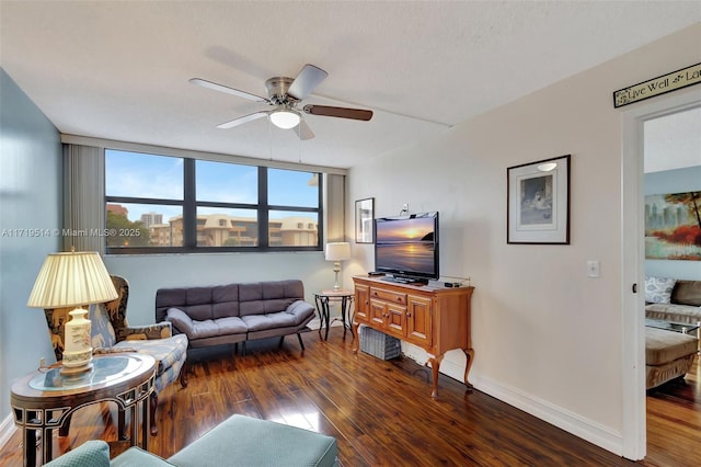 living room featuring ceiling fan and dark hardwood / wood-style floors