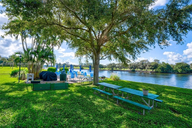 exterior space featuring a lawn and a water view