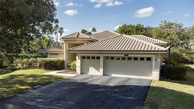 mediterranean / spanish-style home featuring a front lawn and a garage