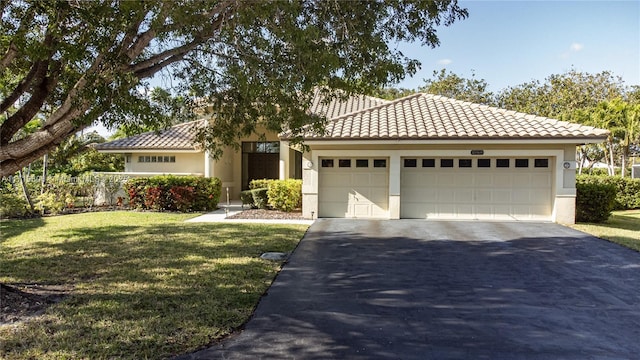 mediterranean / spanish home with a garage and a front lawn