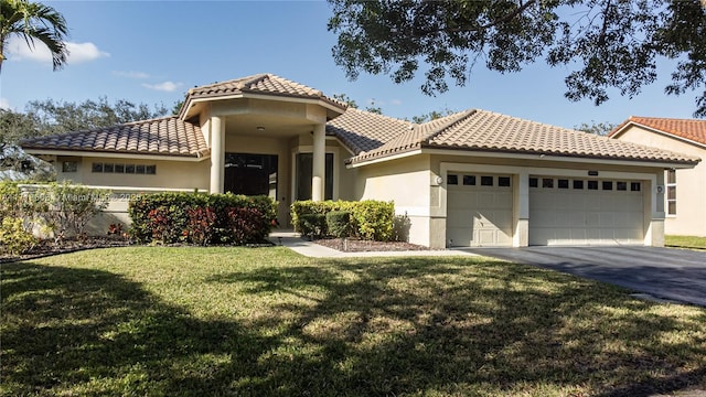 mediterranean / spanish-style house featuring a garage and a front lawn