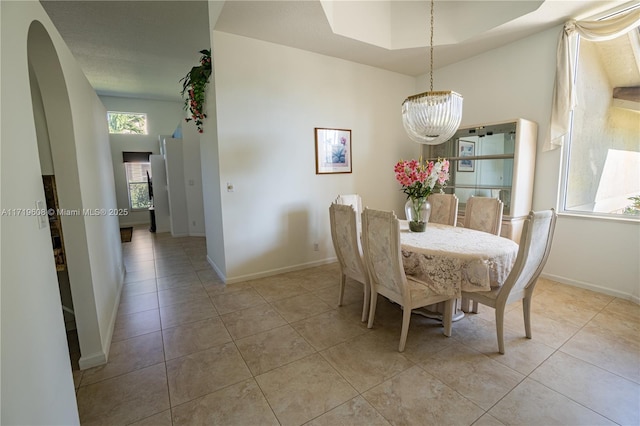 dining area featuring a notable chandelier and light tile patterned flooring