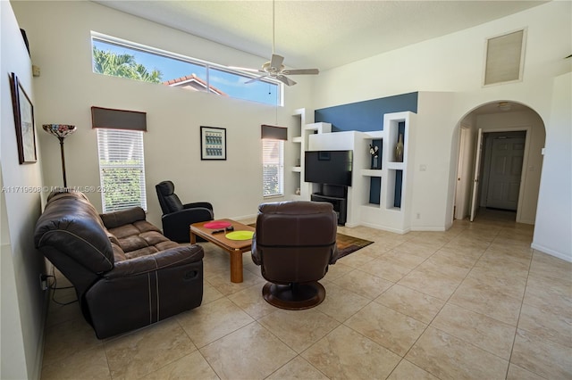 tiled living room with ceiling fan and plenty of natural light