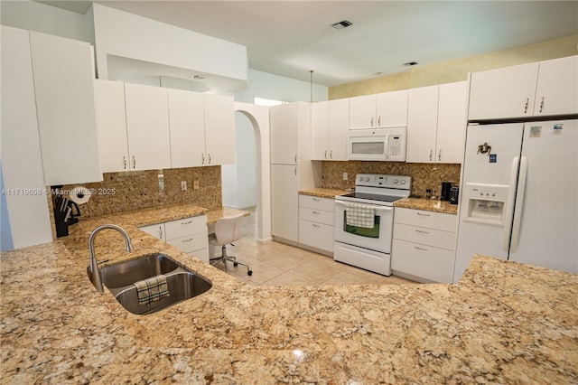 kitchen with decorative backsplash, white cabinetry, sink, and white appliances