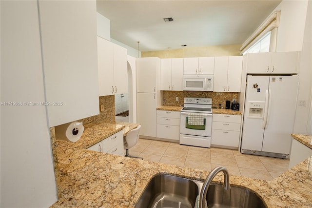 kitchen featuring white appliances, backsplash, white cabinets, sink, and light tile patterned floors