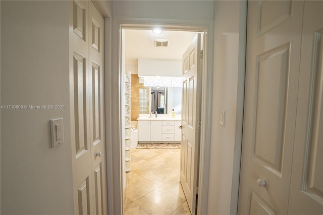 corridor with sink and light tile patterned flooring