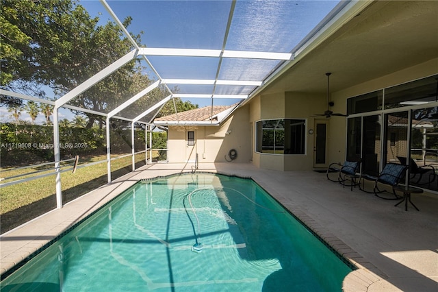 view of pool with a patio, ceiling fan, and a lanai