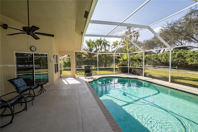 view of pool with glass enclosure and a patio