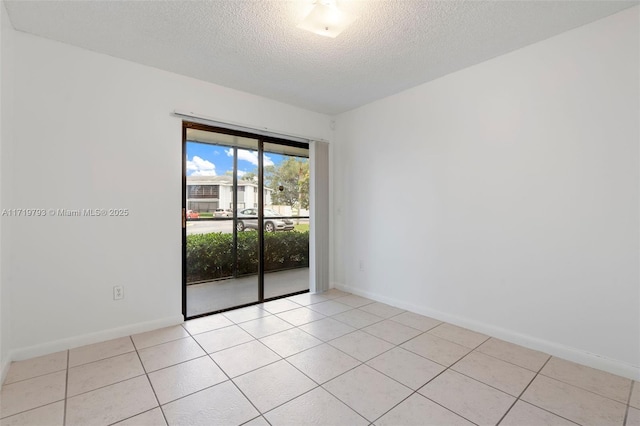 spare room with light tile patterned flooring and a textured ceiling