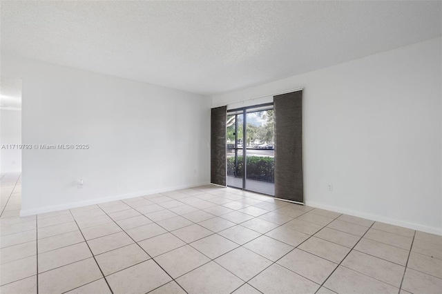 tiled spare room with a textured ceiling