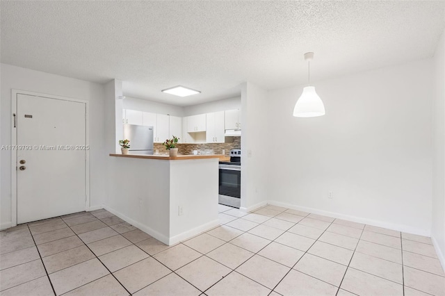 kitchen with stainless steel refrigerator, white cabinetry, kitchen peninsula, pendant lighting, and range