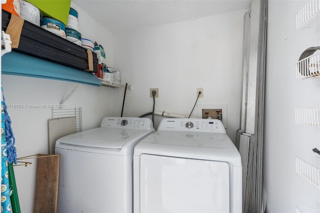 clothes washing area with washer and dryer and a textured ceiling