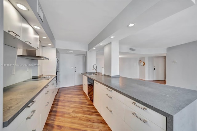 kitchen with white cabinets, black electric stovetop, and light wood-type flooring