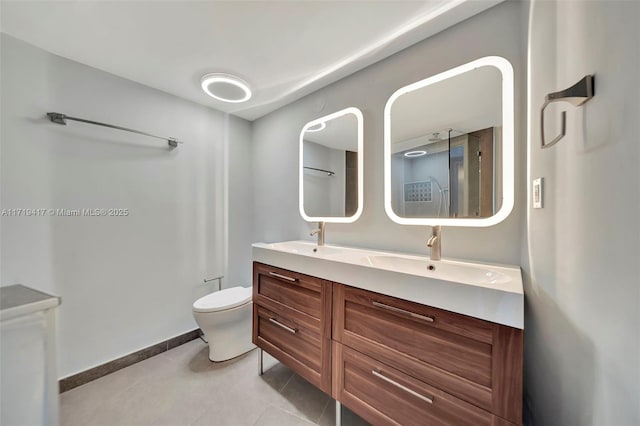 bathroom with toilet, vanity, and tile patterned floors