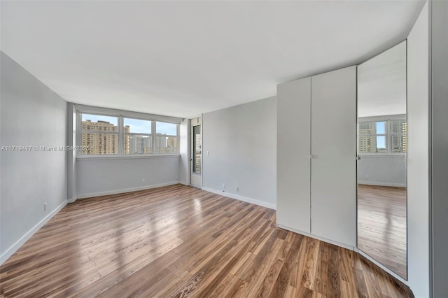 unfurnished room with wood-type flooring