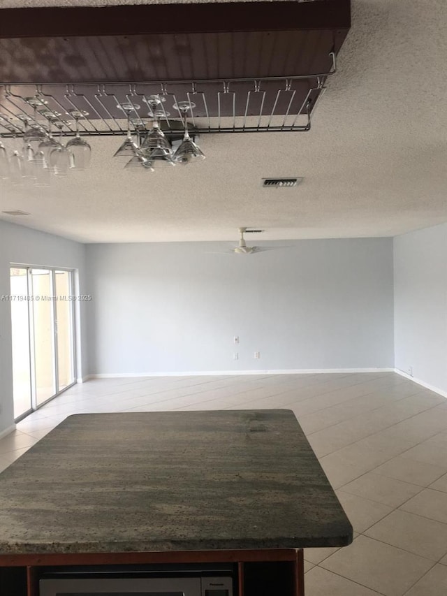 tiled spare room featuring a textured ceiling