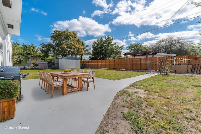 view of patio featuring a grill, a shed, an outbuilding, fence private yard, and outdoor dining area