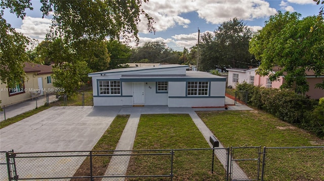 back of property featuring a gate, concrete driveway, a fenced front yard, stucco siding, and a yard