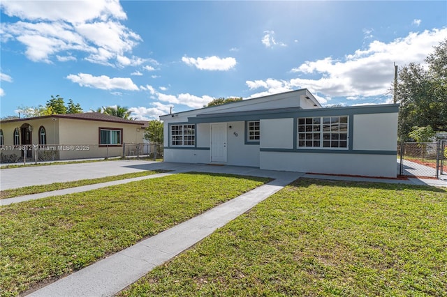 view of front of property with a front yard, fence, and stucco siding