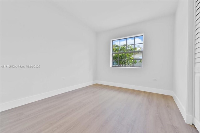 empty room with baseboards and light wood finished floors