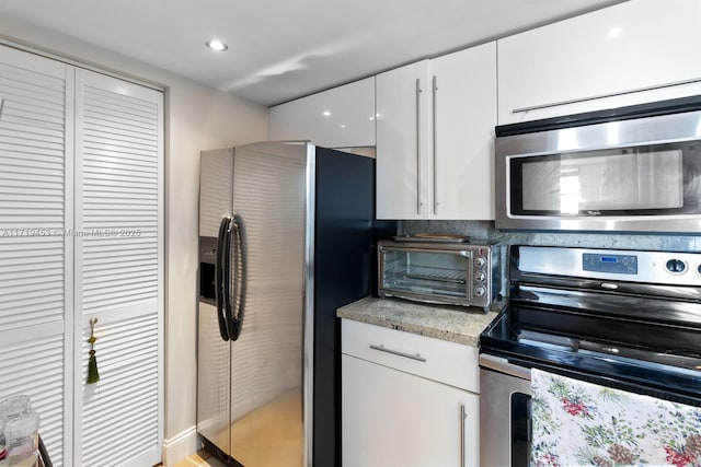 kitchen featuring white cabinets and appliances with stainless steel finishes