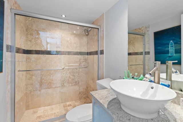 bathroom featuring vanity, an enclosed shower, and toilet