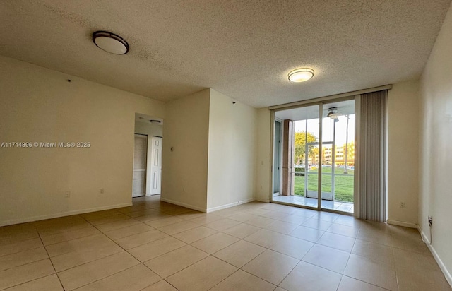 unfurnished room with a textured ceiling, expansive windows, and light tile patterned flooring