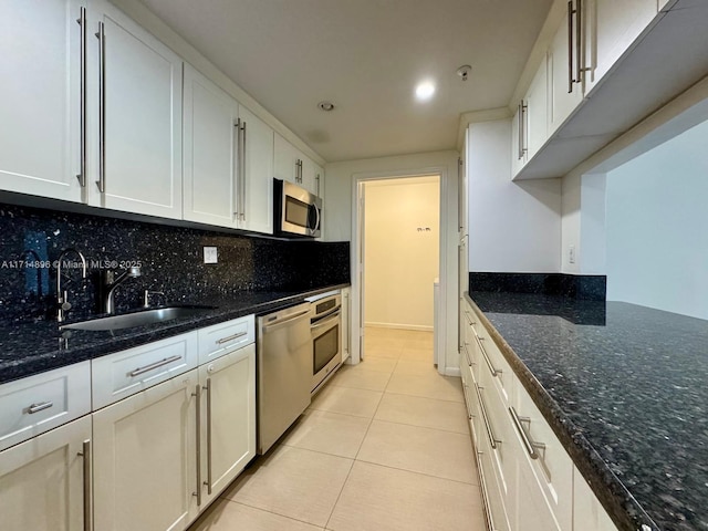 kitchen with backsplash, sink, white cabinetry, and stainless steel appliances