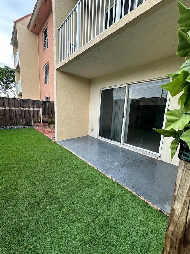 view of yard featuring a patio and a balcony