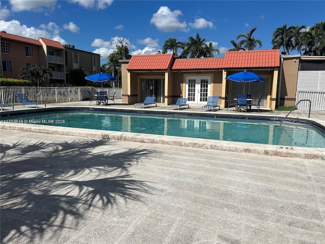 view of swimming pool with french doors and a patio