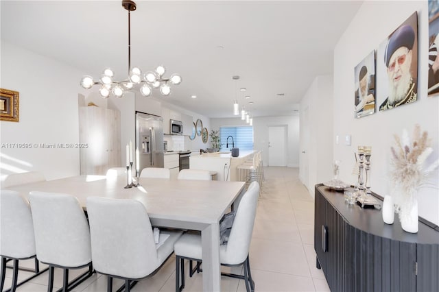 dining room featuring a chandelier, light tile patterned floors, and sink