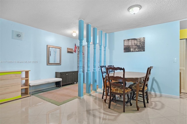 tiled dining space featuring a textured ceiling